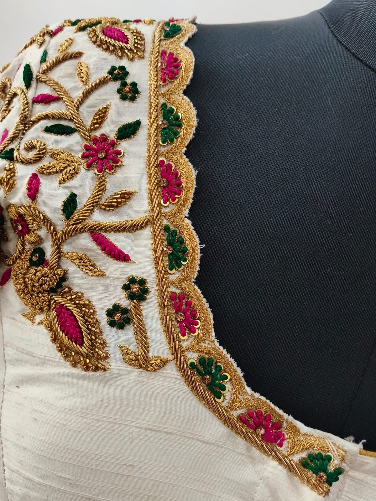 Ivory neckline with embroidered gold peacocks and pink leaves